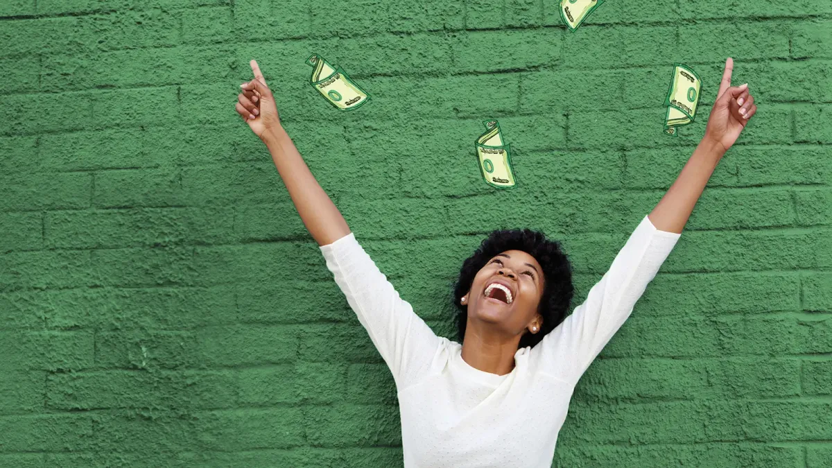 Women cheering with dollar bills falling around her