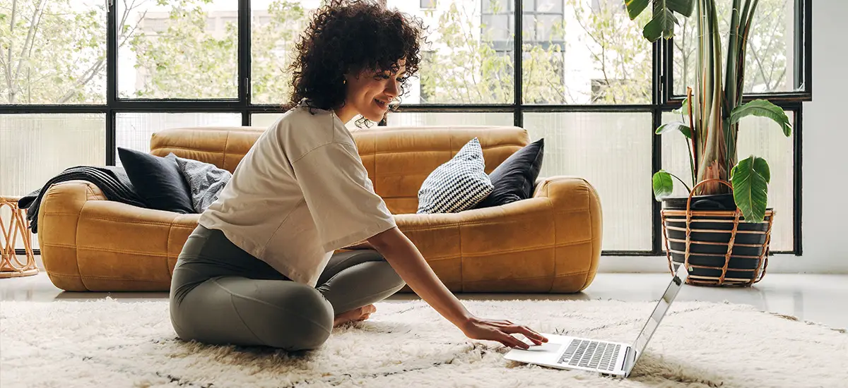 sitting on a rug with a house plant